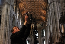 Ben Trenchard sets up a microphone in the quire