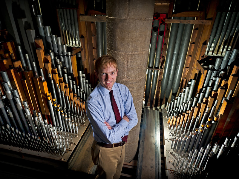 Former Director of Music, Robert Quinney, standing amongst the organ pipes